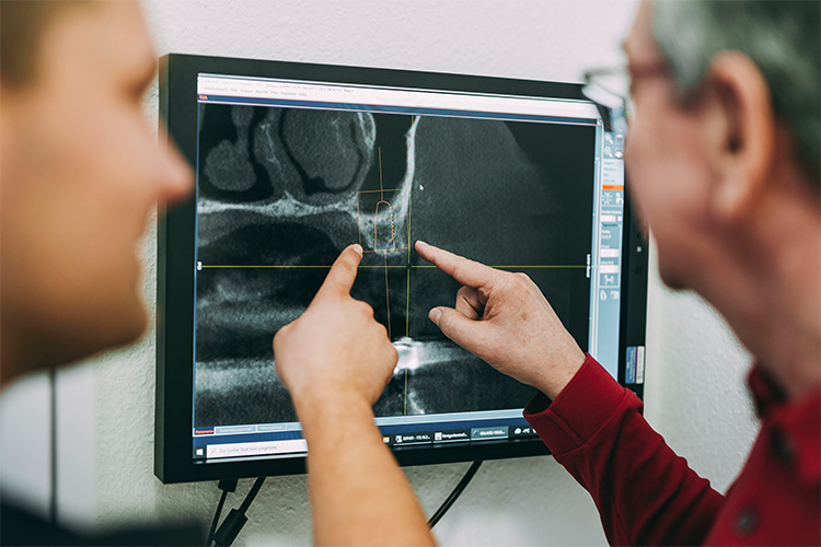 Dr. Theel und ein Patient schauen sich die Röntgenbilder an in der Zahnarztpraxis Matthias Theel in Hilpoltstein
