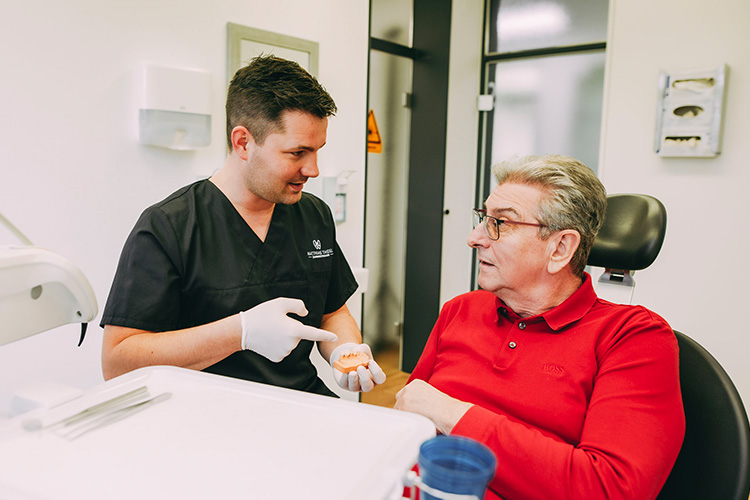 Dr. Matthias Theel in einem Gespräch mit einem Patienten zum Thema Knochenaufbau in der Zahnarztpraxis Matthias Theel in Hilpoltstein